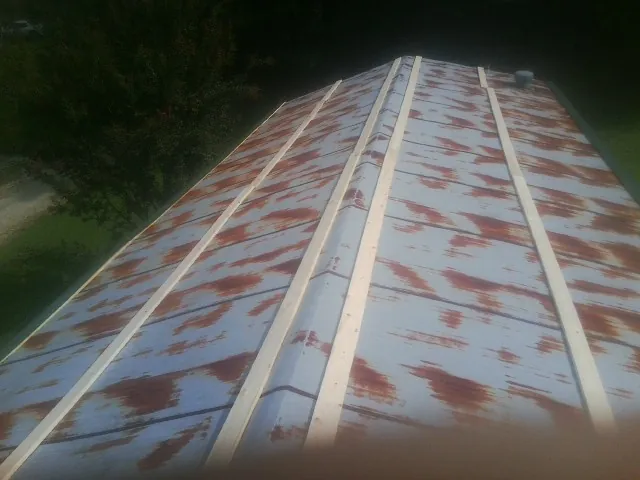 Rusted metal roof panels with new wood purlins before replacement — Storm Damage Roof Repair in Whiteside by Roofing Brothers