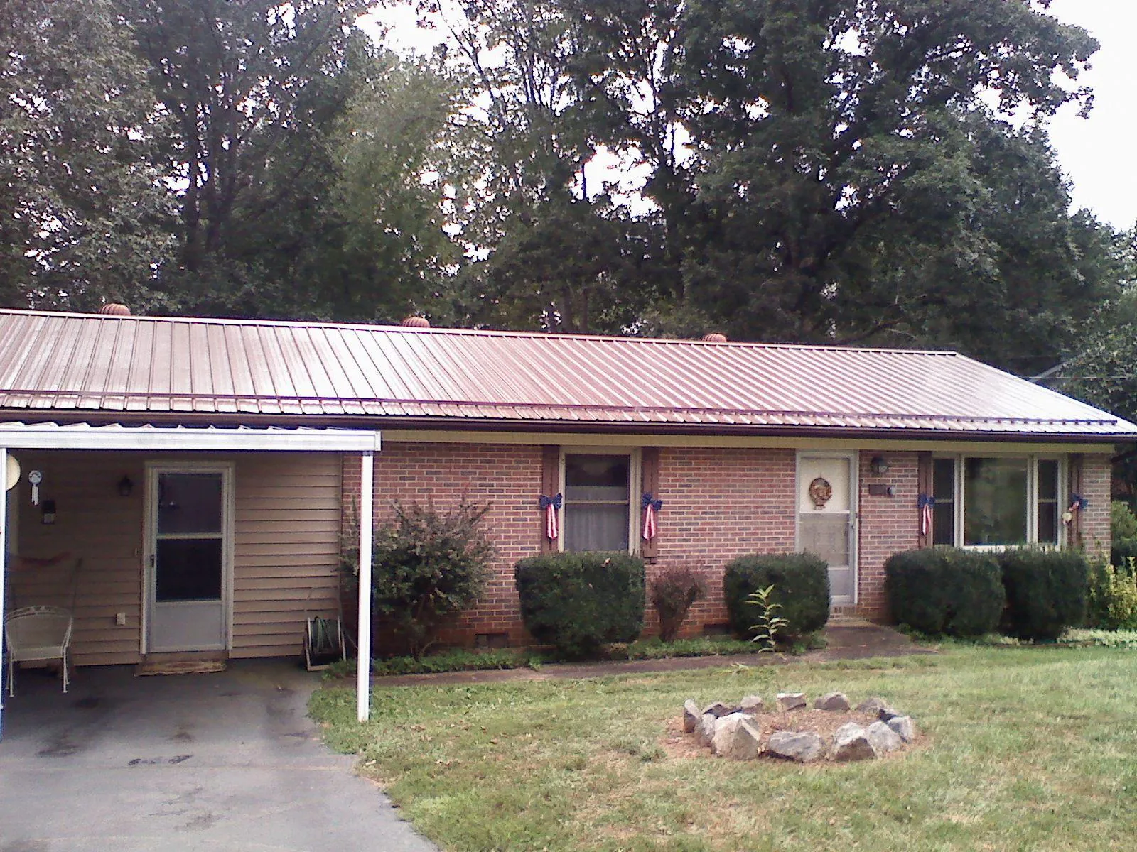 Bronze metal roof and carport on a brick ranch home — Roof Repair work by our crew in Whiteside