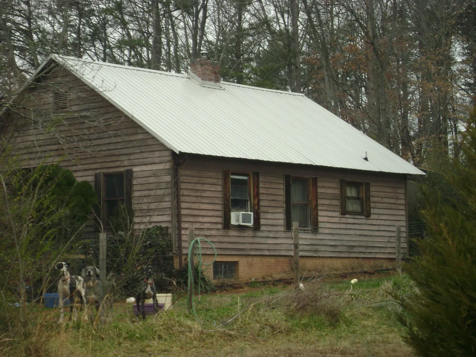 White metal roof on an old wood sided farmhouse, from a Metal Roof Installation job in Whiteside